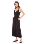 Woman wearing black Dana Cropped Jumpsuit with V-neck and cropped wide legs, styled with flat shoes