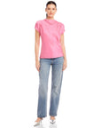 Woman wearing pink Emmeline blouse made from silky cupro material with cowl mock neck and split cap sleeves paired with blue jeans