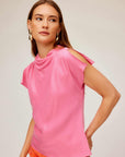 Woman wearing pink Emmeline blouse with silky cupro material and split cap sleeves