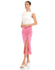 Woman wearing pink Fiona Shirred Midi Skirt with side shirring and high slit paired with white sleeveless top and heels