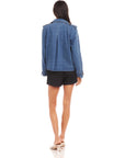 Woman wearing a blue denim Chelsea Cropped Trench jacket with long raglan sleeves and boxy fit shown from the back