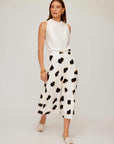 Woman wearing a high-waisted midi Lexi Skirt with Sahara Twill print and sleeveless white top