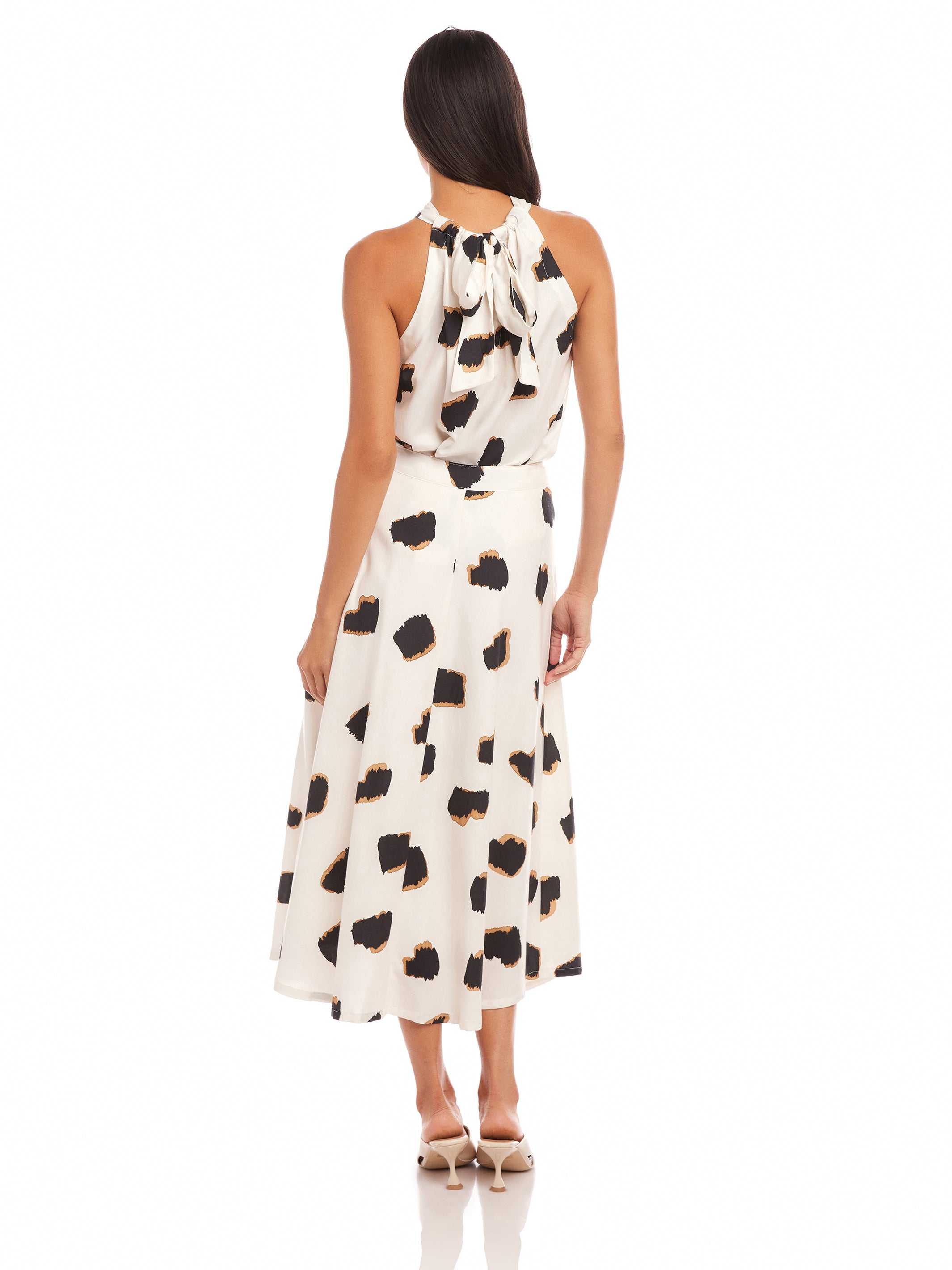 Woman wearing a high-waisted, flowy midi Lexi Skirt with Sahara twill print and side zipper closure from the back