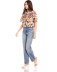 Woman wearing Nadine Bow Detail Top with front tie closure and high-waisted jeans