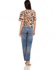 Woman wearing Nadine Bow Detail Top with stamped batik cotton poplin and high waist jeans, back view