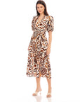 Woman wearing a brown and white paisley print Poppy Shirred Waist Dress with puff sleeves and side slit