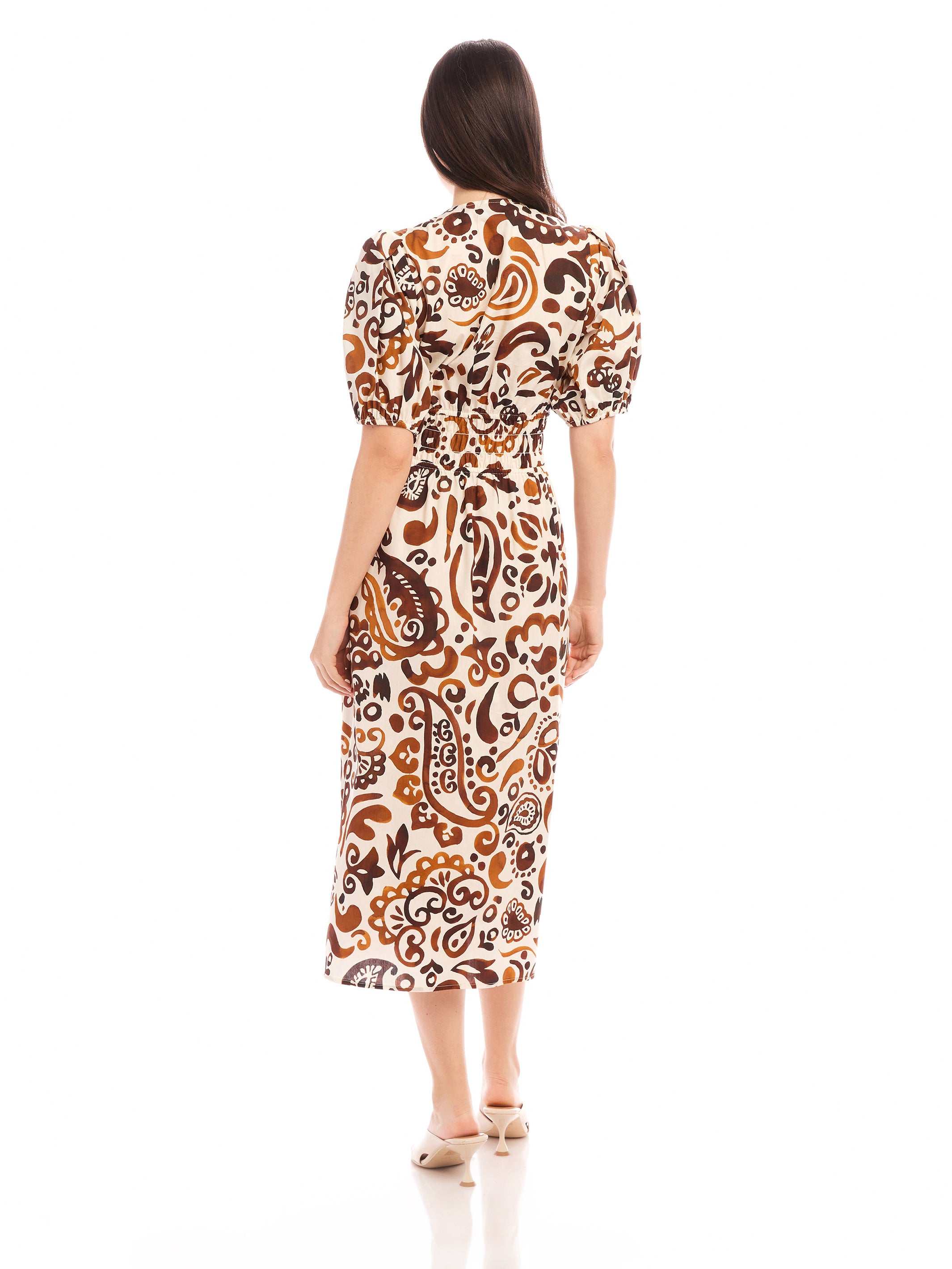 Woman wearing Poppy Shirred Waist Dress with paisley print and short puff sleeves, back view