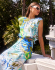 Woman wearing sleeveless Sami top with botanical scarf print and adjustable waist tie, paired with matching skirt outdoors