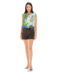 Woman wearing sleeveless Sami top with botanical scarf print and adjustable waist tie paired with black denim shorts
