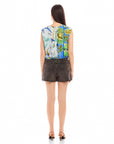 Back view of woman wearing sleeveless Sami top with botanical scarf print and adjustable waist tie, paired with black high-waist shorts.