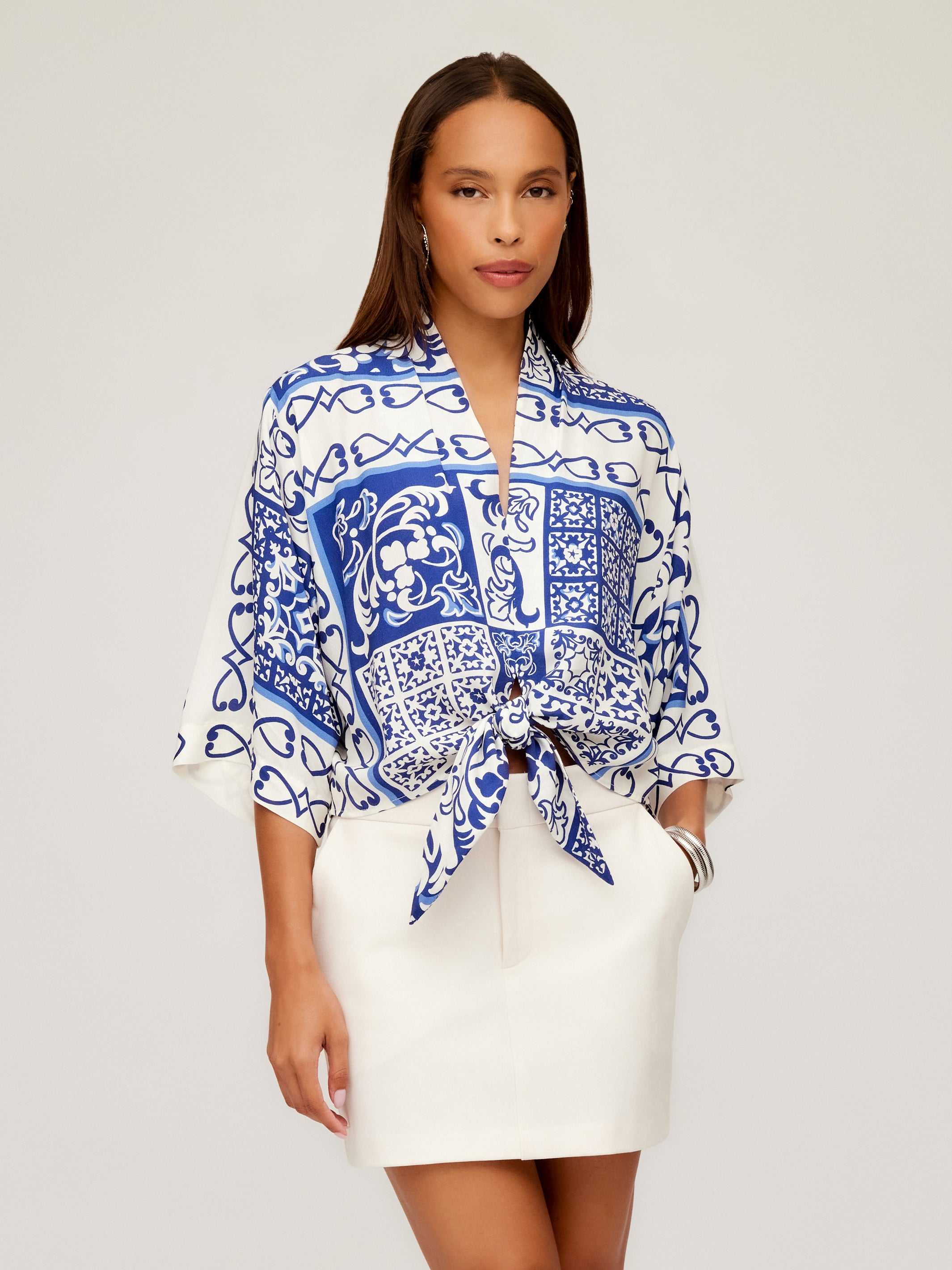 Woman wearing Maribel Modern Skirt in white with side pockets and a blue and white patterned tied blouse