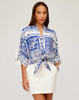 Woman wearing Maribel Modern Skirt in white with side pockets and a blue and white patterned tied blouse