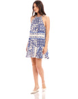 Woman wearing sleeveless Brenda Ruffle Hem Dress in capri scarf print crepe with halter neck and back tie closure