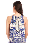 Back view of a woman wearing the Brenda Ruffle Hem Dress in capri blue scarf print crepe with halter neck and back tie closure