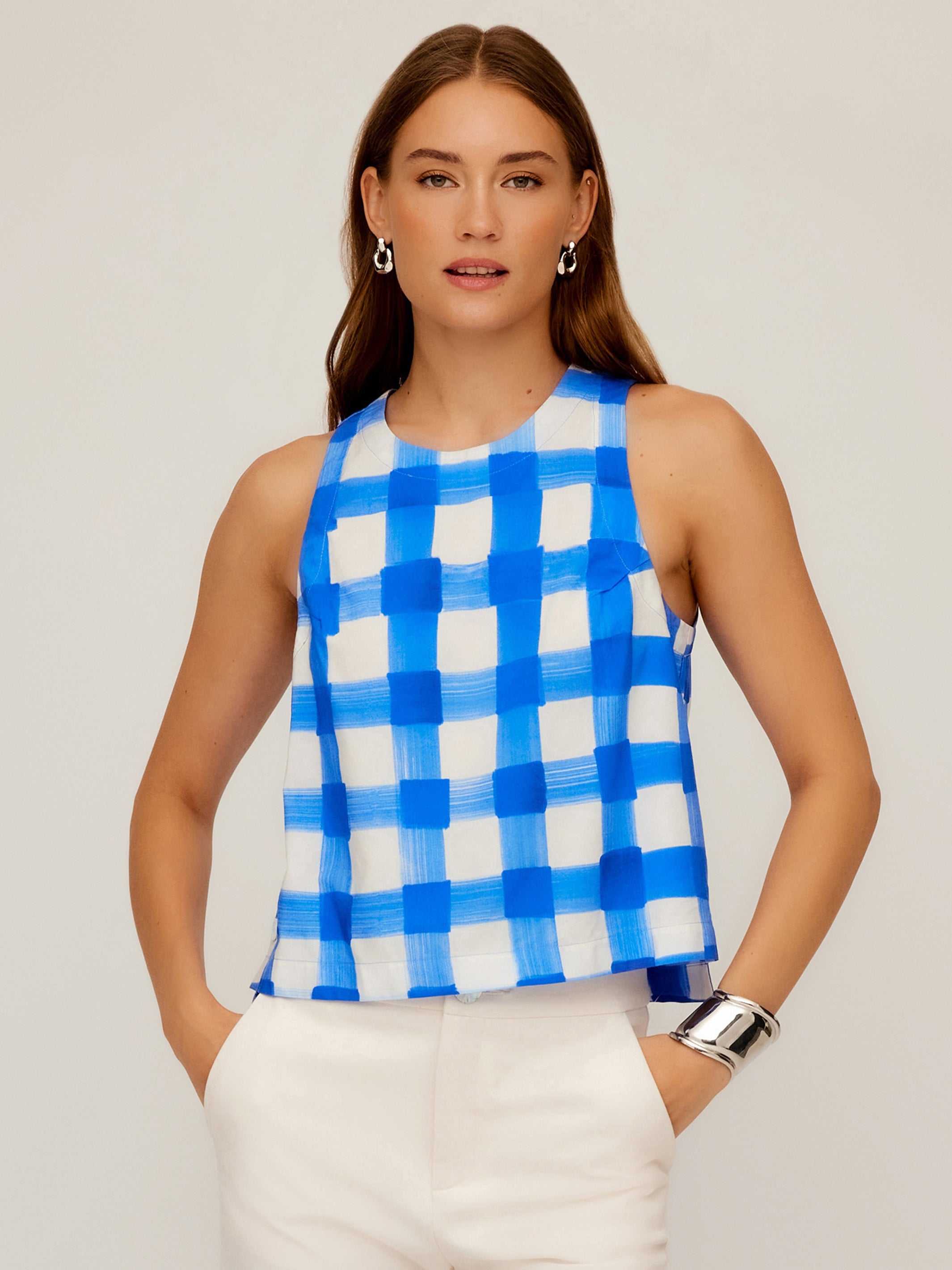 Woman wearing sleeveless Beatrix Button Tank with blue Italian watercolor check print and round neckline.