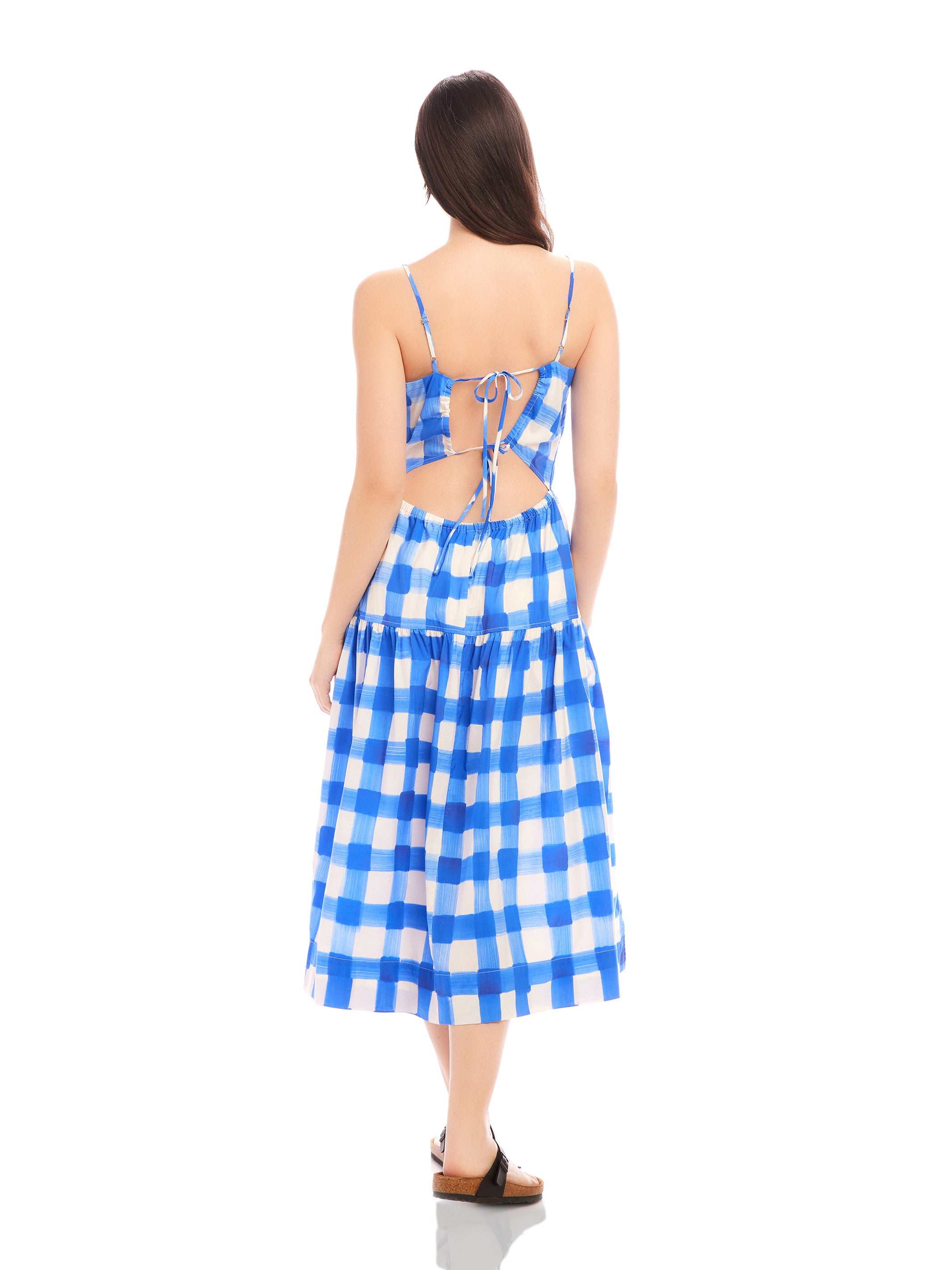 Woman wearing Costa Dress in blue and white watercolor check print with open back and adjustable spaghetti straps