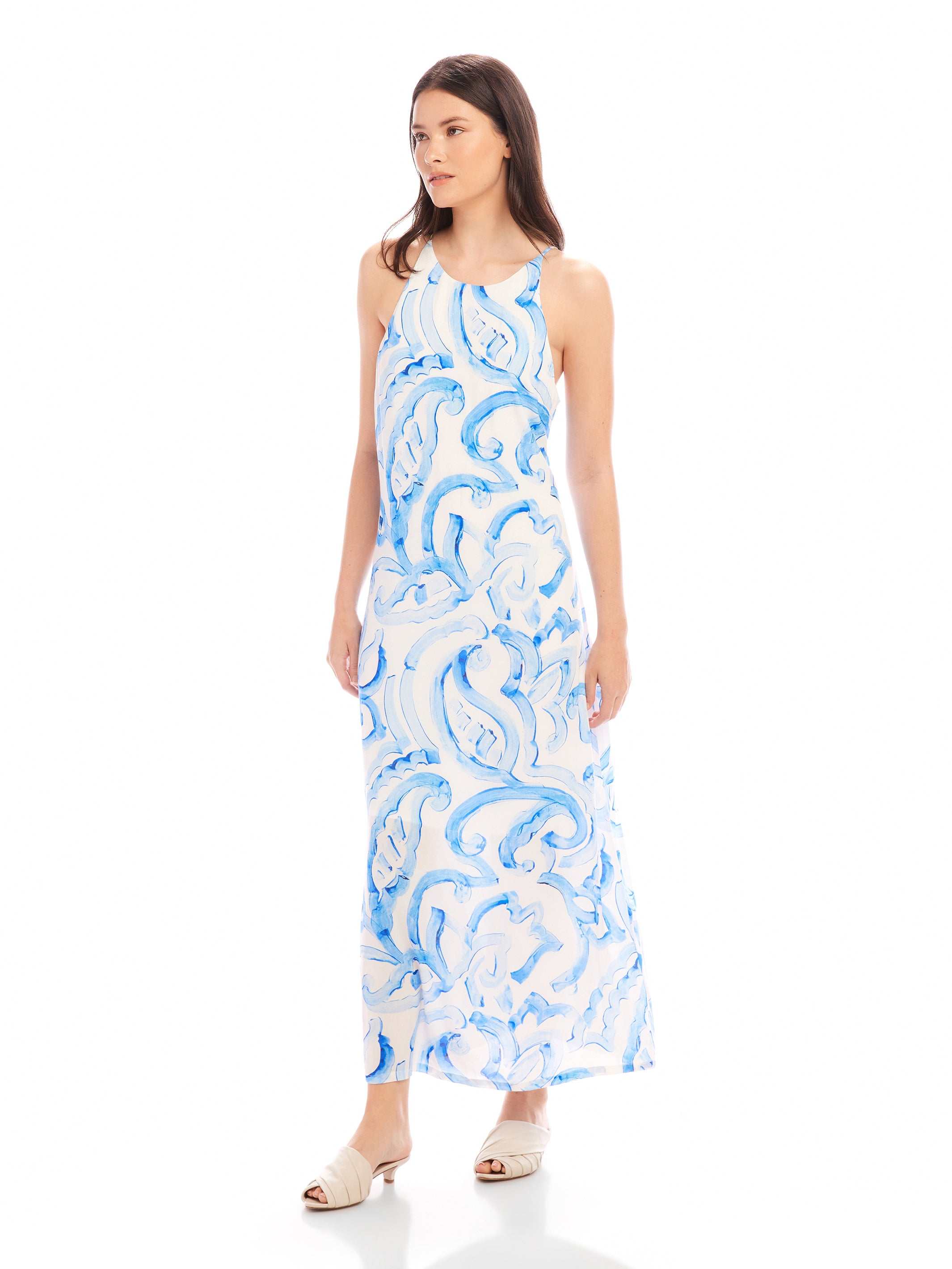 Woman wearing Sera A-Line Dress with blue painted paisley print and adjustable spaghetti straps in maxi length