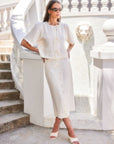 Nadine Bow Detail Top in cream linen with front tie closure and short puff sleeves paired with matching buttoned midi skirt