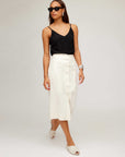Woman wearing a white Lori Midi Skirt with front buttons and a black sleeveless top.