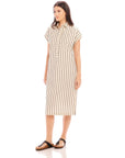 Woman wearing a sleeveless Lucia Stripe Dress with vertical stripes, collar, side slit, and buttons down the front, styled with sandals.