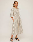 Woman wearing Rhea Stripe Skirt midi length cotton skirt with vertical stripes and elasticized sheered waist