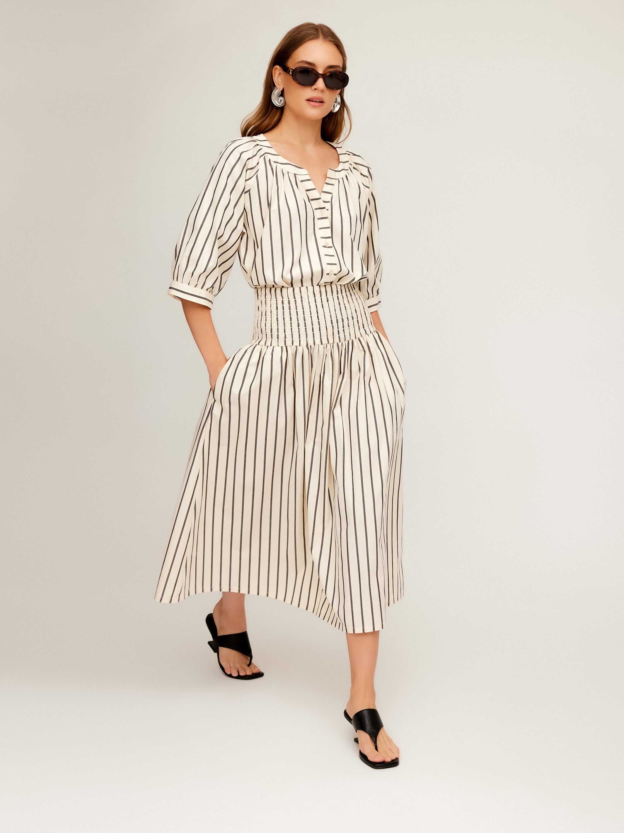 Woman wearing Rhea Stripe Skirt midi length with elasticized high waist in striped cotton fabric