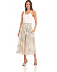 Woman wearing midi length Rhea Stripe Skirt with elasticized sheered waist and vertical stripes