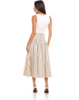 Woman wearing a Rhea Stripe Skirt midi length striped cotton skirt with elasticized sheered waist, styled with a white sleeveless top and black heels.