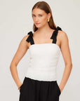 Woman wearing a white Annie Ribbon Tie Top with black adjustable tie straps and square neckline