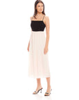 Woman wearing Anetta Contrast Midi Dress with fitted black top and flowy white skirt, spaghetti straps and square neckline.