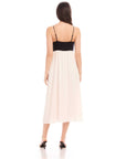 Back view of woman wearing Anetta Contrast Midi Dress with black fitted top and flowy white skirt, adjustable spaghetti straps, and midi length.