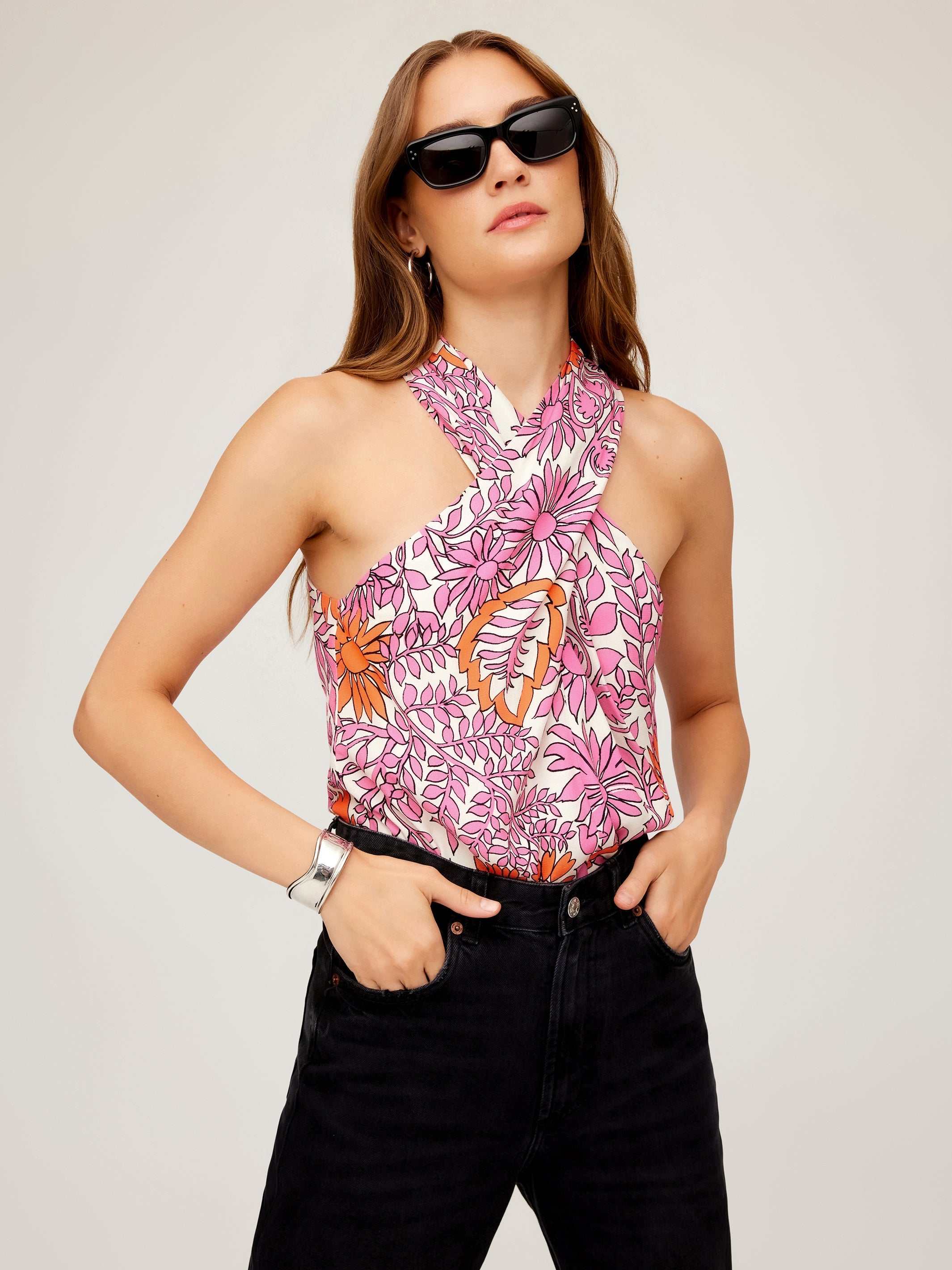 Woman wearing Sasha halter top with vibrant retro floral print and black sunglasses