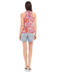 Woman wearing Sasha Halter Top with retro floral print and denim shorts, back view