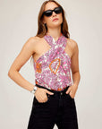 Woman wearing Sasha halter top with vibrant retro floral print and black sunglasses