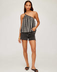 Woman wearing Louetta One-Shoulder Tank with black and white stripes and metallic gold foil detail paired with black shorts