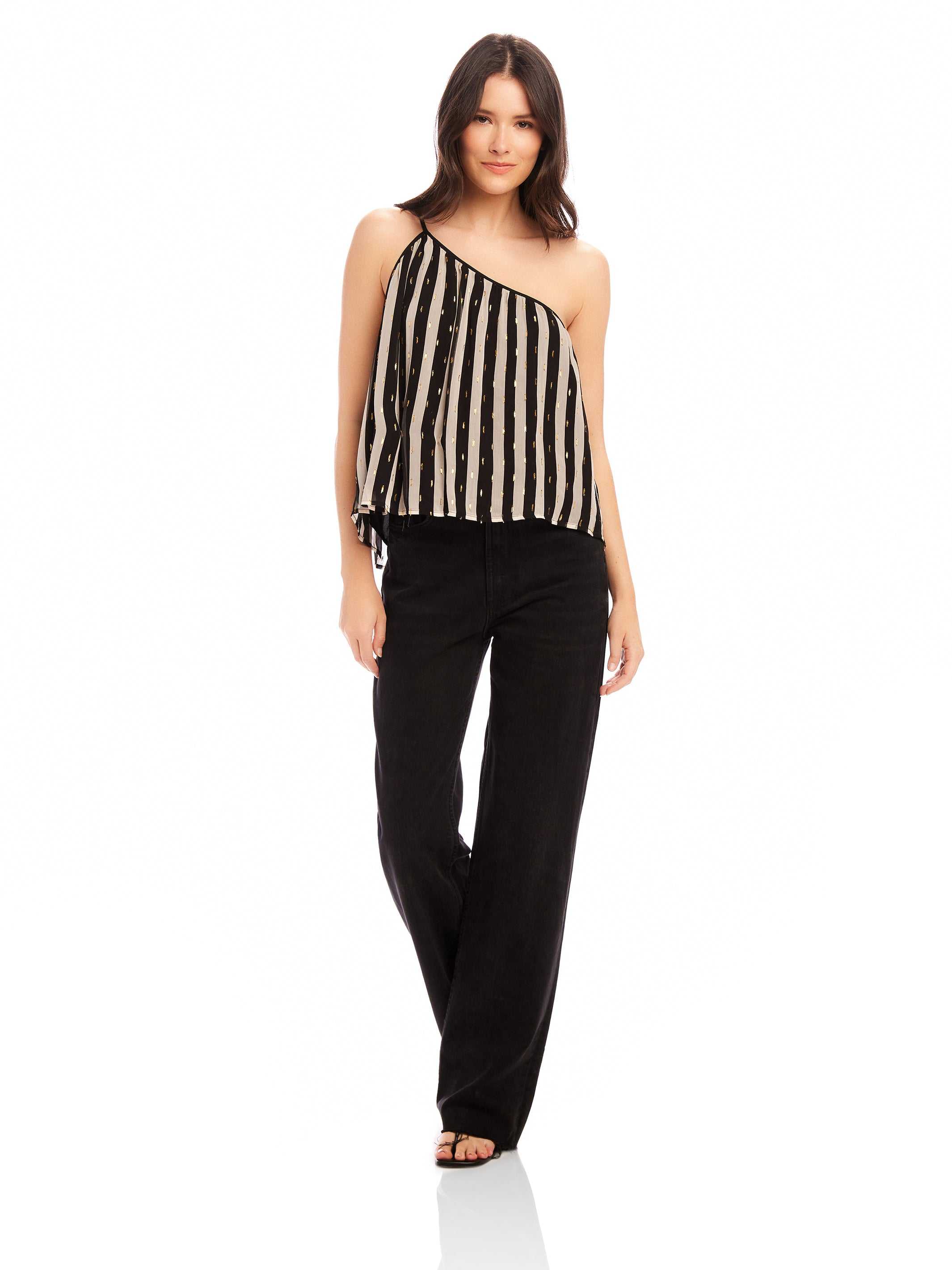 Woman wearing Louetta One-Shoulder Tank with black and white stripes and metallic gold foil detail paired with black pants