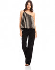 Woman wearing Louetta One-Shoulder Tank with black and white stripes and metallic gold foil detail paired with black pants