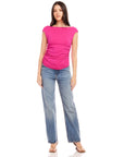 Woman wearing pink Tasha Side-Shirred Top with cap sleeves and boatneck paired with blue jeans