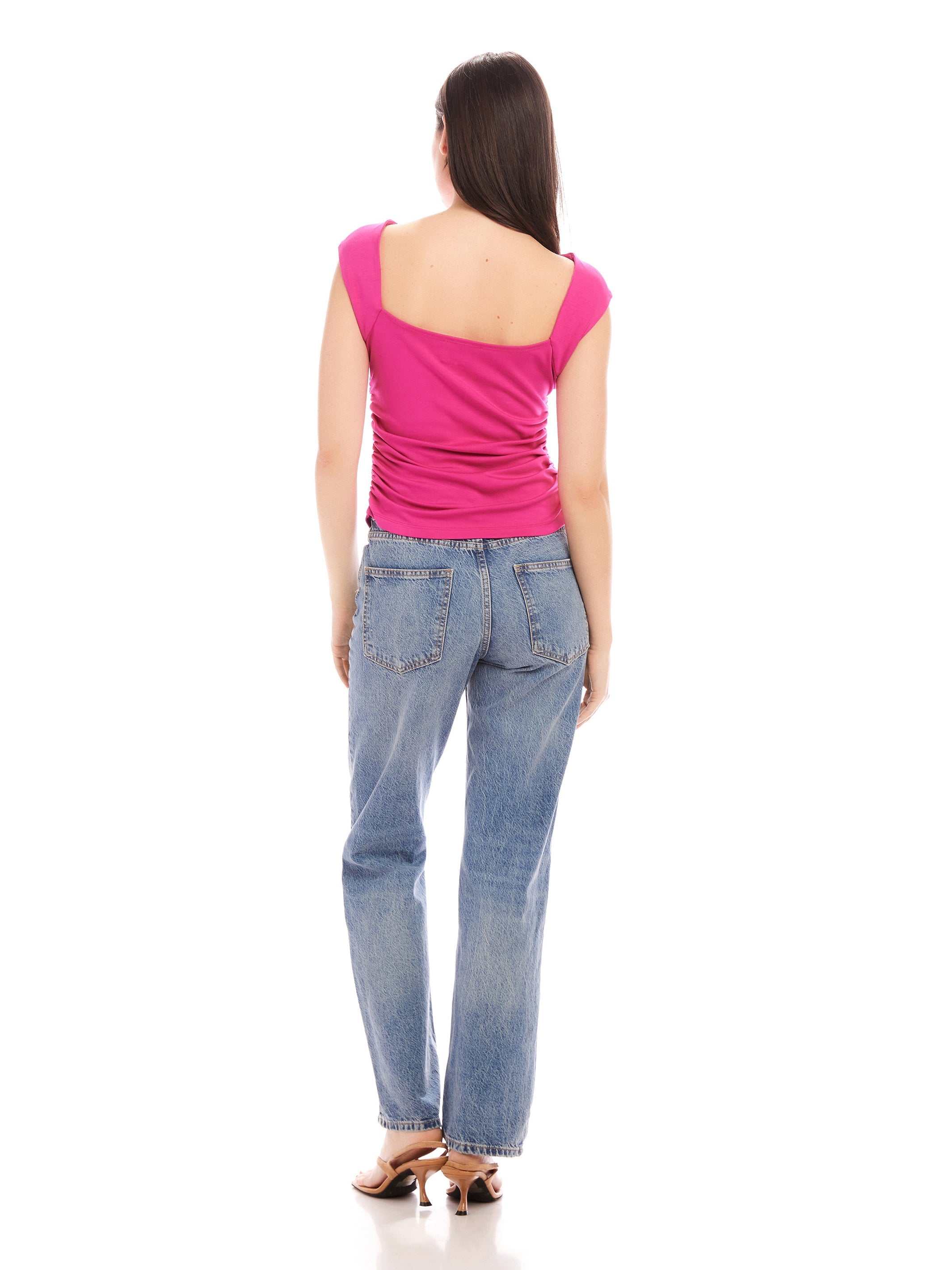 Woman wearing pink Tasha Side-Shirred Top with open back and blue jeans viewed from behind