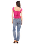 Woman wearing pink Tasha Side-Shirred Top with open back and blue jeans viewed from behind