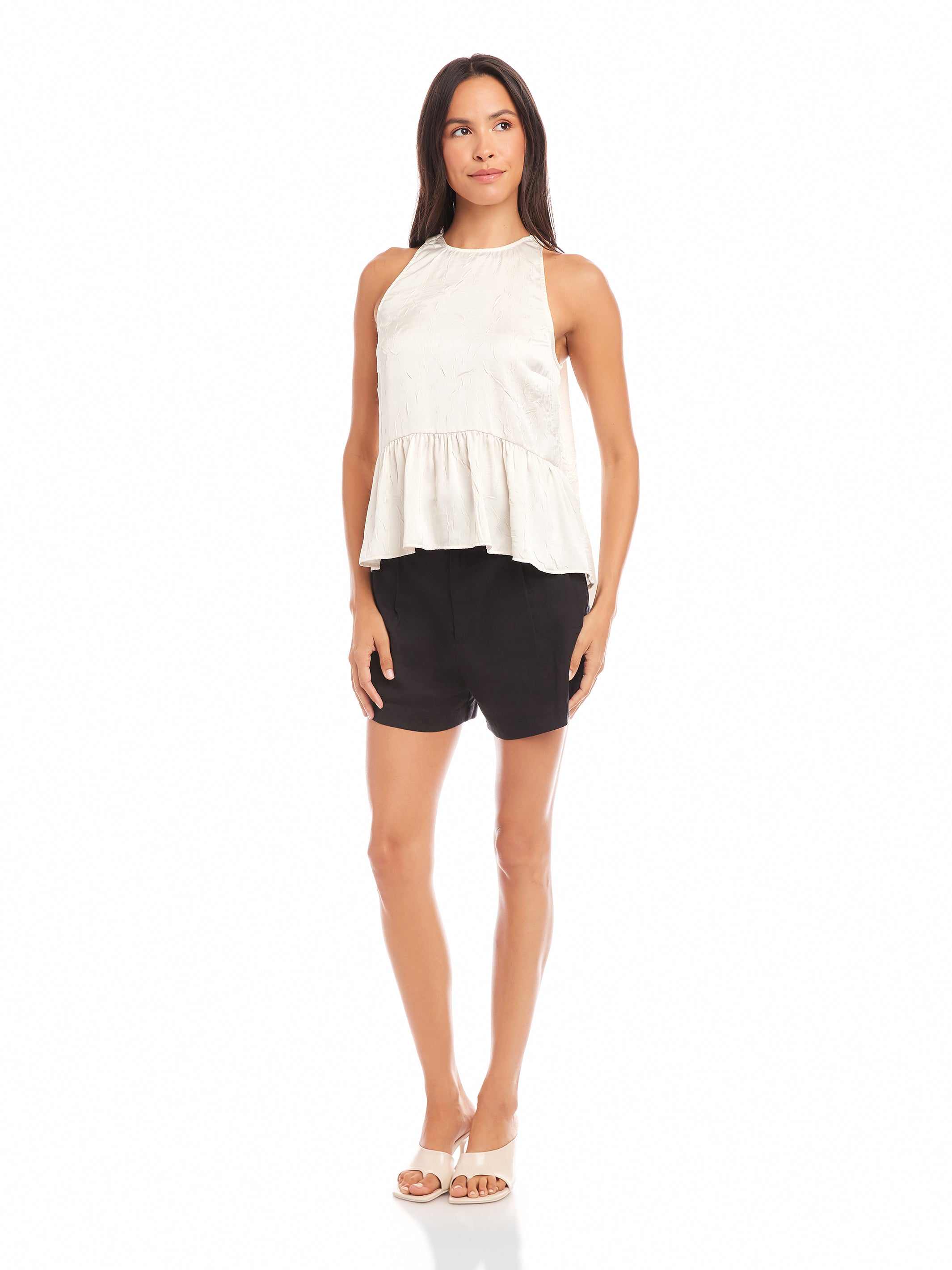 woman wearing Floren Ruffle Hem halter top with high-low hem and black shorts