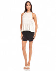 woman wearing Floren Ruffle Hem halter top with high-low hem and black shorts