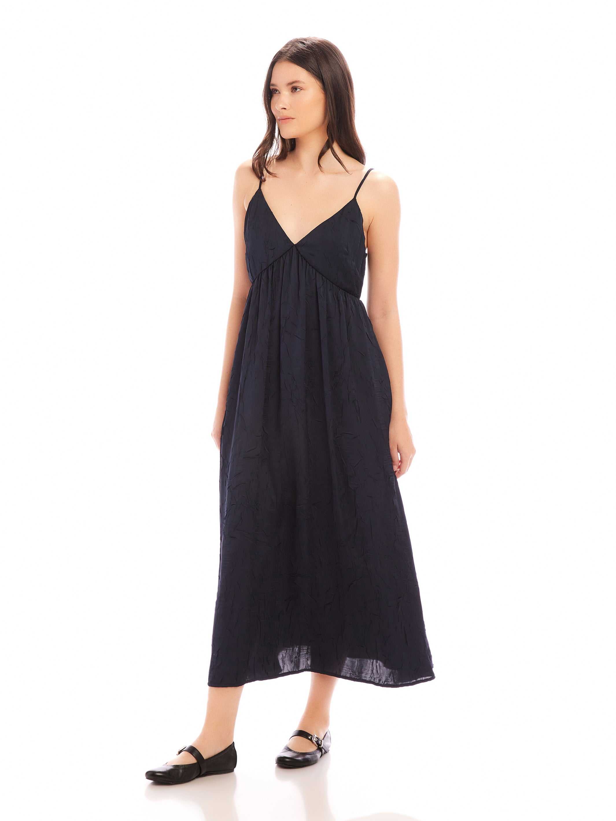 Woman wearing a black Leanna Midi Dress with adjustable spaghetti straps and V-neckline