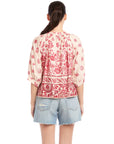 Back view of Rilyn Border Print Top with pink floral watercolor design and elbow blouson sleeves paired with denim shorts