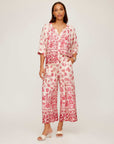 Woman wearing Etta Border Print Pants with watercolor border design and wide leg fit in red and white.