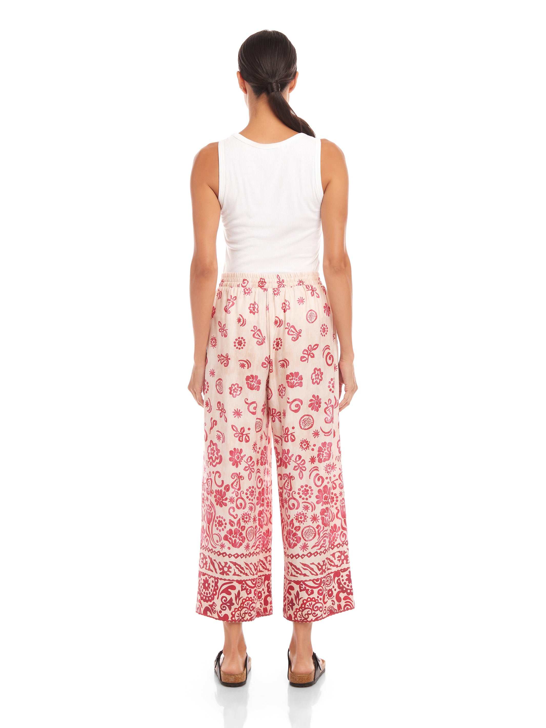 Woman wearing Etta Border Print Pants with wide leg and watercolor floral border pattern.
