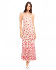 Model wearing a Jaylen Border Print Dress with a fitted silhouette, halter neckline, watercolor floral border design, and side slits.