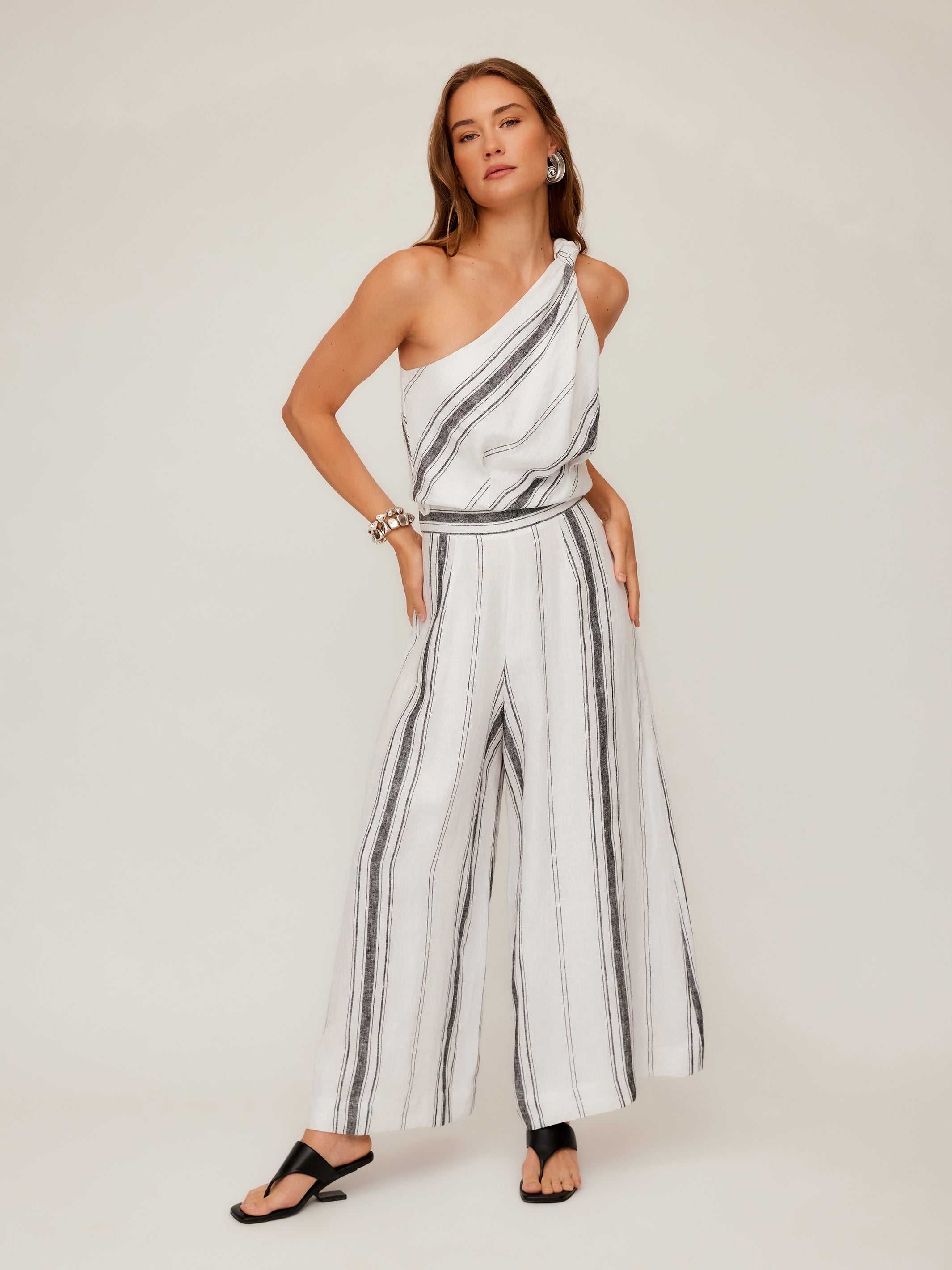 Woman wearing Vanita One-Shoulder Top striped linen blend with knotted detail and wide-leg pants