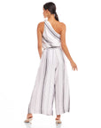 Back view of a woman wearing a striped Vanita One-Shoulder Top paired with wide-leg pants