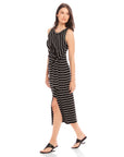 Woman wearing black and white striped sleeveless Maddie Side-Knot Midi Dress with side slit and round neckline.